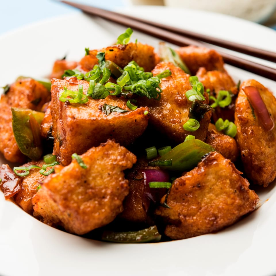 CURRYZONE's chili paneer, a popular Indian appetizer, garnished with green onions and bell peppers.